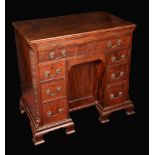 A George III mahogany kneehole desk, moulded top above a slide,