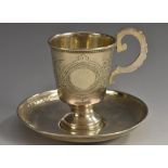 A Russian silver cup and saucer, scroll handle,