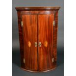 A George III mahogany and marquetry bow-fronted wall-hanging corner cupboard,