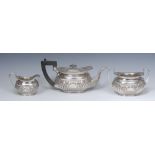 A silver three piece boat shaped teapot, milk jug and sugar bowl,