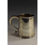 A George V silver pint mug, of George II design, scroll-capped handle, skirted base, 11cm high,