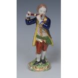 A Derby figure of a boy, playing a flute, wearing a blue jacket,