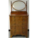 An Edwardian mahogany dressing chest, oval mirror, moulded oversailing top, five graduated drawers,