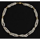 A culture two strand pearl and gold coloured metal bead necklace, twisting barrel clasp,