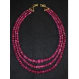 A three strand faceted ruby bead necklace,