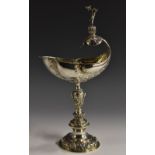 An Edwardian Historicist silver copy of an Elizabethan shell cup, crested by a scantily clad putto,