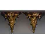 A pair of late 19th century gilt metal and mahogany wall brackets,