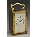 An early 20th century brass carriage clock, with Roman numerals, bevelled glass panels,