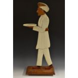 An Anglo-Indian 'blackamoor' coasting waiter, carved and painted as a turbaned attendant, he stands,