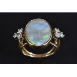 An opal and diamond ring, central oval opal panel flashing, violet, green,