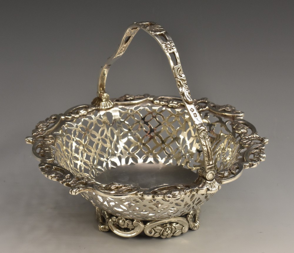 A late Victorian silver shaped circular swing-handled sweetmeat basket,