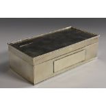 An Art Deco silver rectangular table cigarette box, engine turned overall, hinged cover,