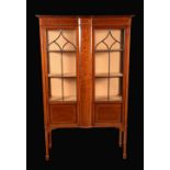 An Edwardian mahogany display cabinet, moulded oversailing top above a deep frieze,