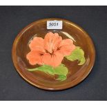 Ceramics - a Moorcroft circular dish, Hibiscus pattern, brown ground, 19cm diam. approx.