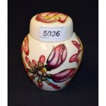 A Moorcroft ginger jar and cover, decorated with lilies on a magnolia ground,