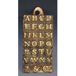 A brass horn book, cast in relief with the alphabet, to verso St Paul's, AD 1729,