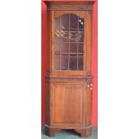 An oak floor standing corner cupboard, outswept cornice, astragal glazed door to top,