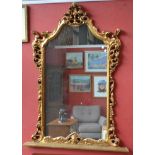 A large 20th century Rococo style ornate gilt framed over mantel mirror,