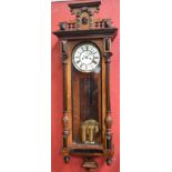 A Vienna wallclock, architectural pediment, enamelled dial, Roman numerals, susidiary seconds,