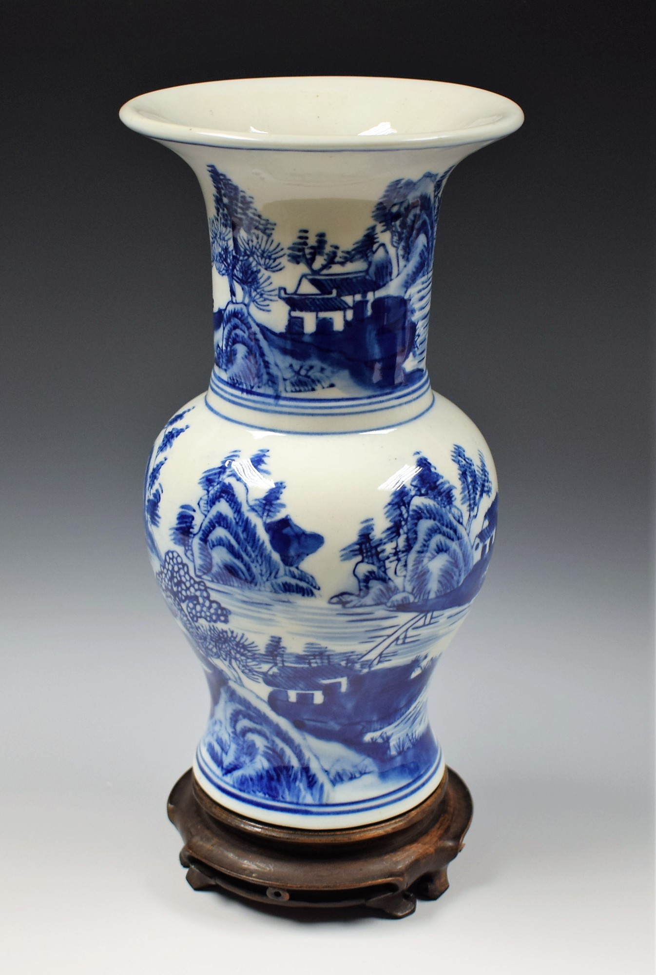 A Chinese gu shaped vase, painted in tones of underglaze blue with landscapes, 26.