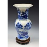 A Chinese gu shaped vase, painted in tones of underglaze blue with landscapes, 26.