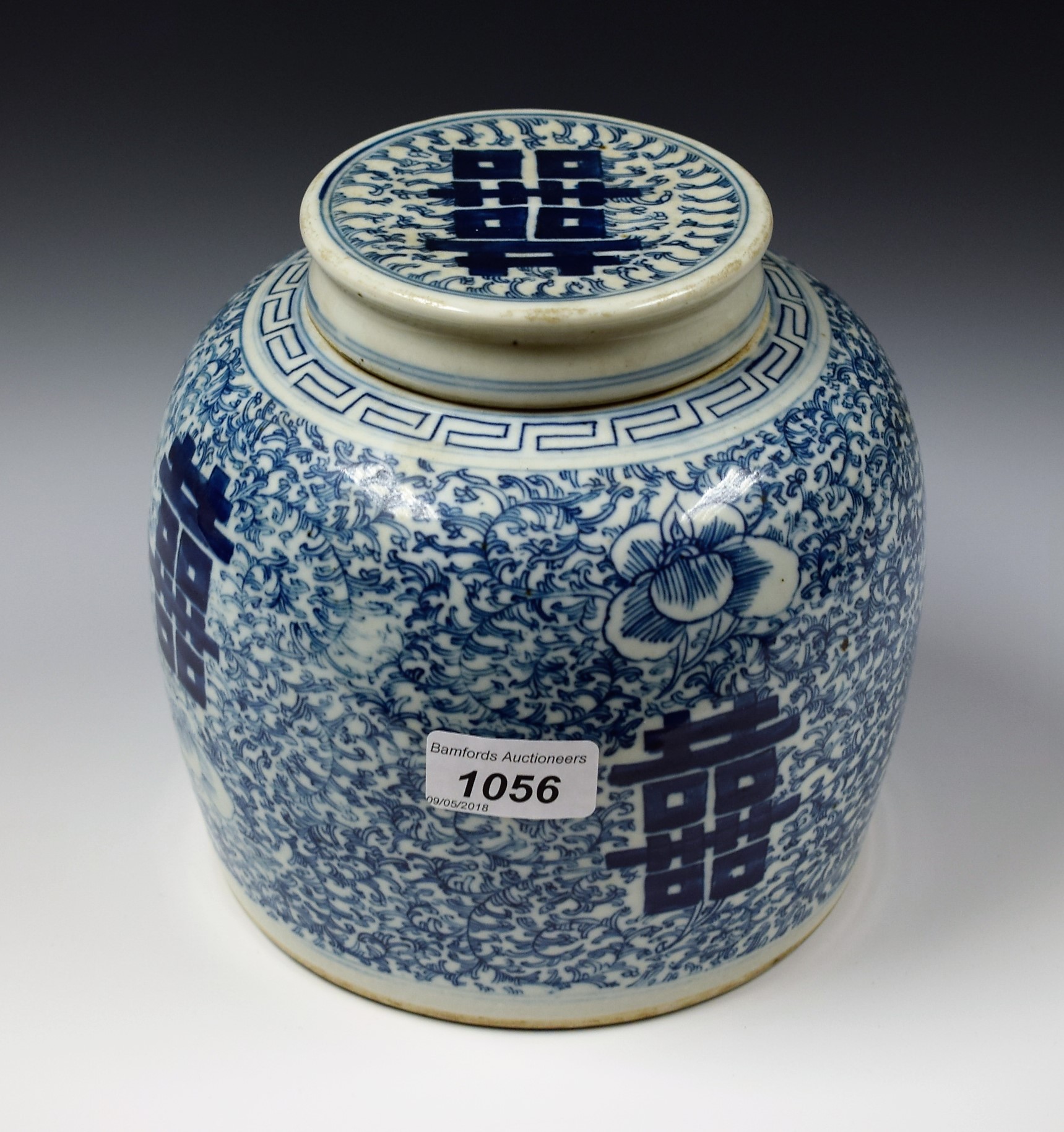 A Chinese ovoid ginger jar and cover, painted in tones of underglaze blue with symbols,