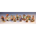 Goebel ceramic figures including Strolling Along, Happy Days, Accordion Boy, Skier Boy,