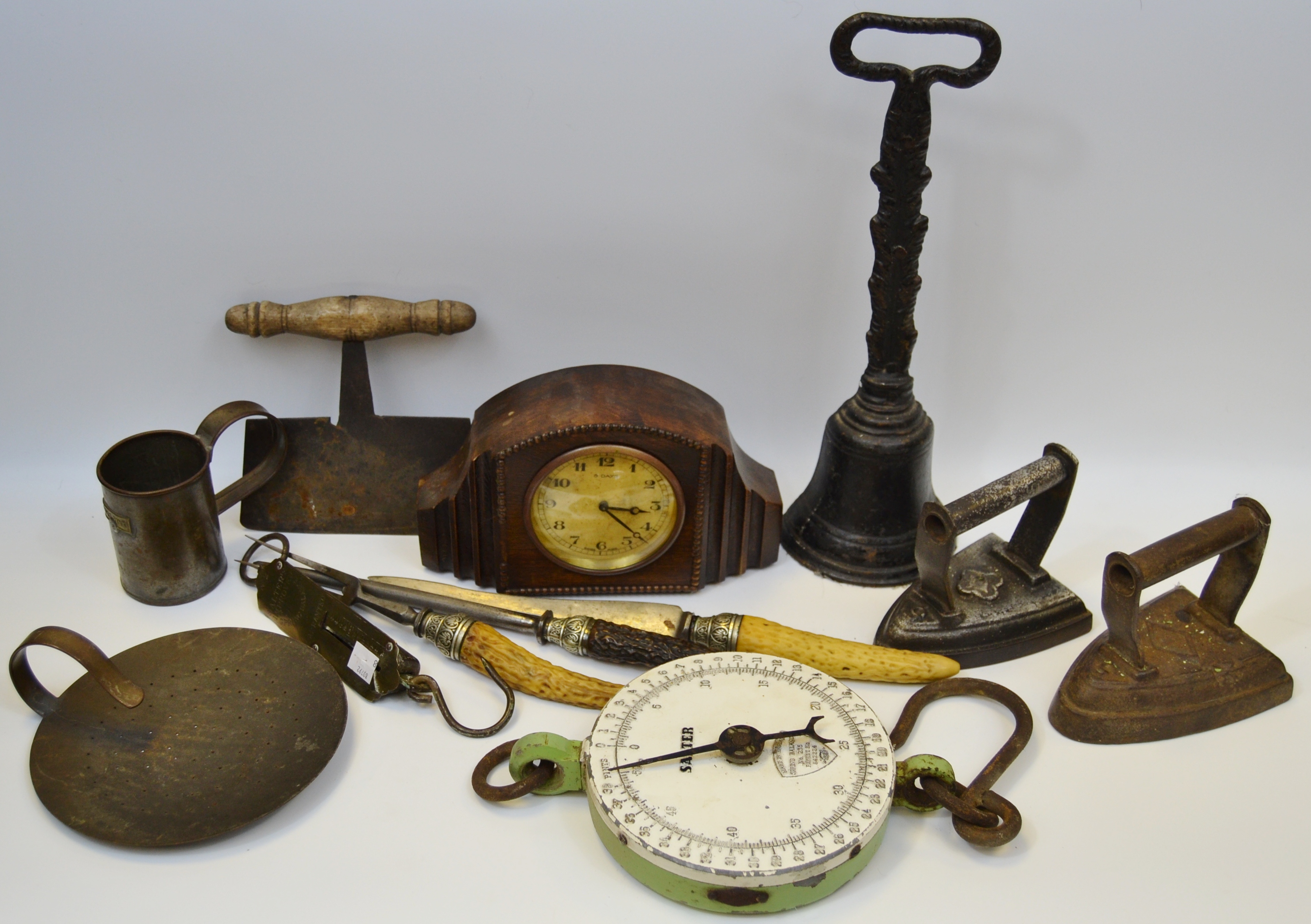 An early 19th century door porter; early 20th century oak mantel clock; 19th century dough cutter;