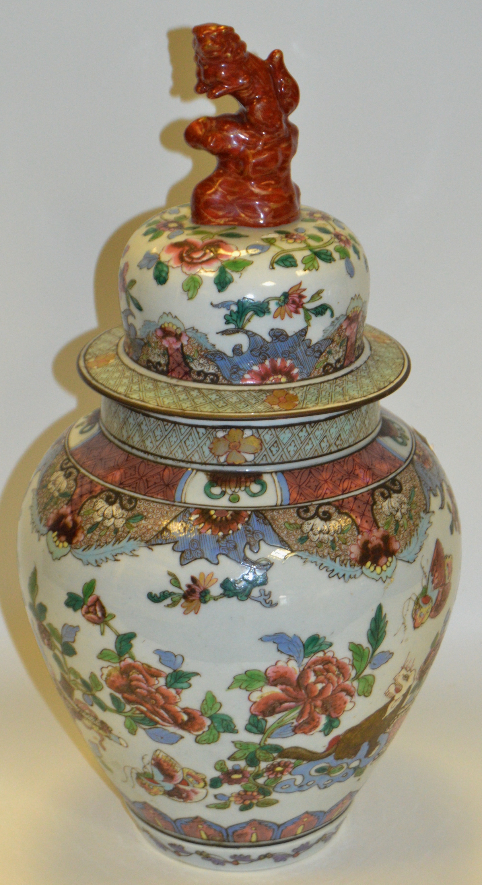 A Oriental temple jar and cover, decorated with stylised flowers and foliage, Lion finial,