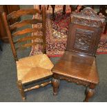 A 19th century oak refectory chair profusely carved throughout,