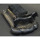 A 20th century cast iron boot scraper, in the form of a Dachshund, with brush, shaped base,