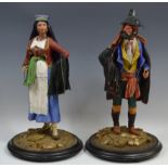 A pair of Continental papier mache figures, of Romany travellers, standing in colourful dress,
