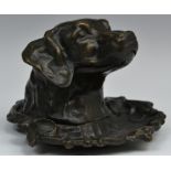 A dark patinated bronze inkwell, as the head of a retriever, hinged cover, 15cm wide,