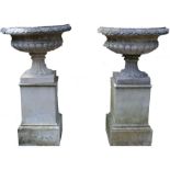 A pair of Regency design composition campana shaped garden urns, half fluted, square plinths,