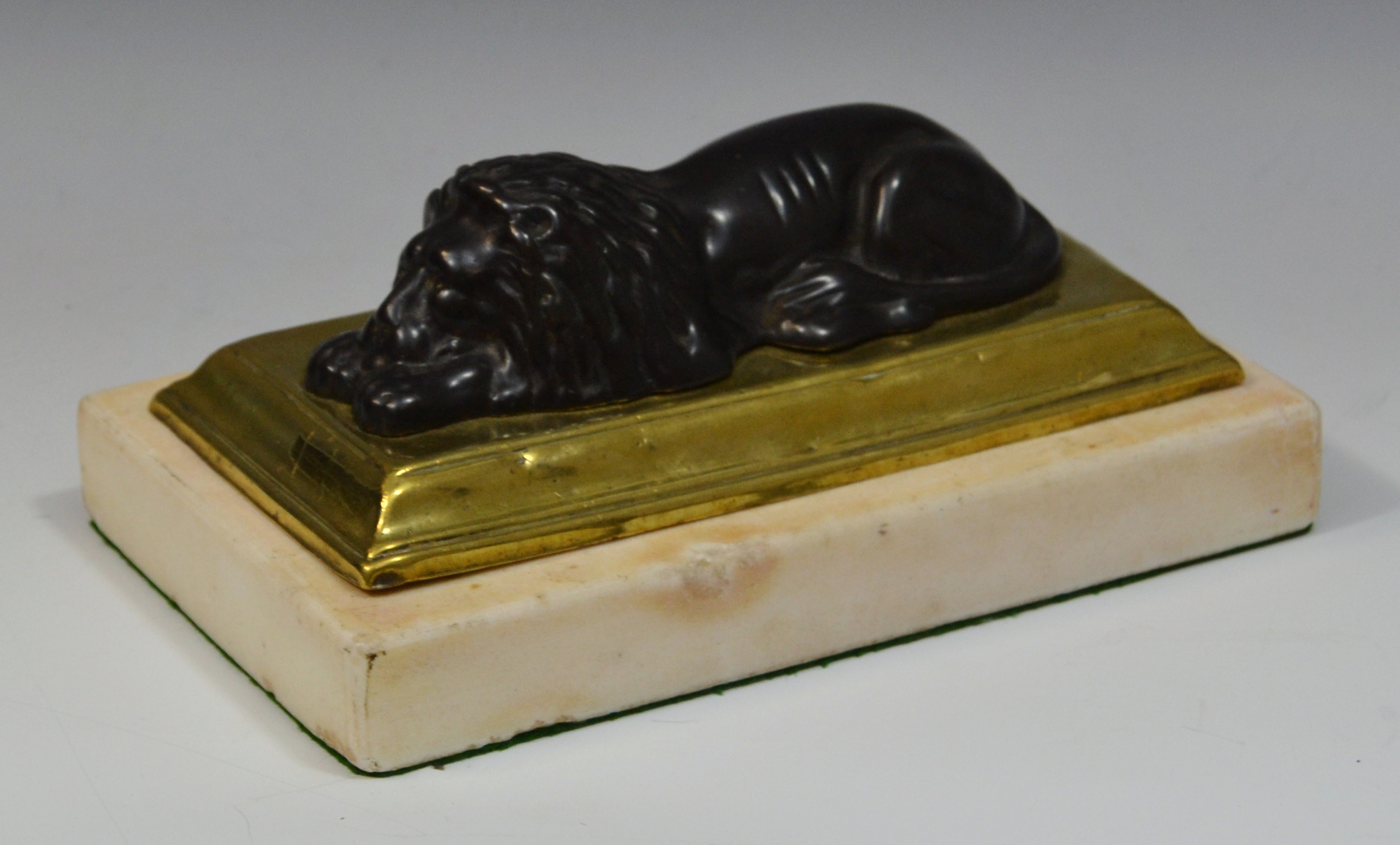 A 19th century bronze desk weight, of a recumbent lion, brass base, marble plinth, 22cm long, c.