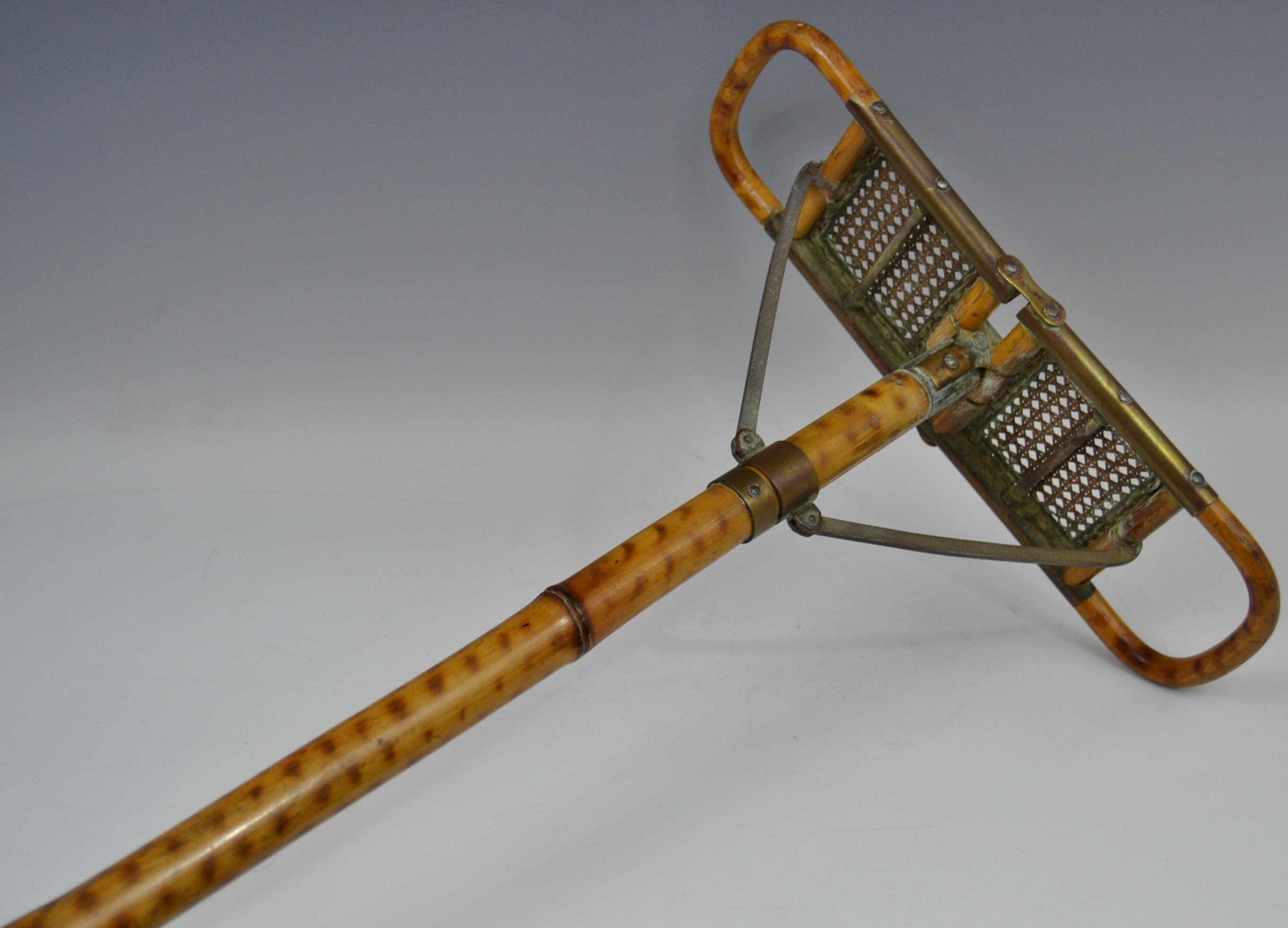 An early 20th century bamboo shooting stick, the caned seat folding for carriage,