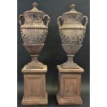A pair of Venetian style terracotta two handled garden urns, in relief with anthemions and foliage,