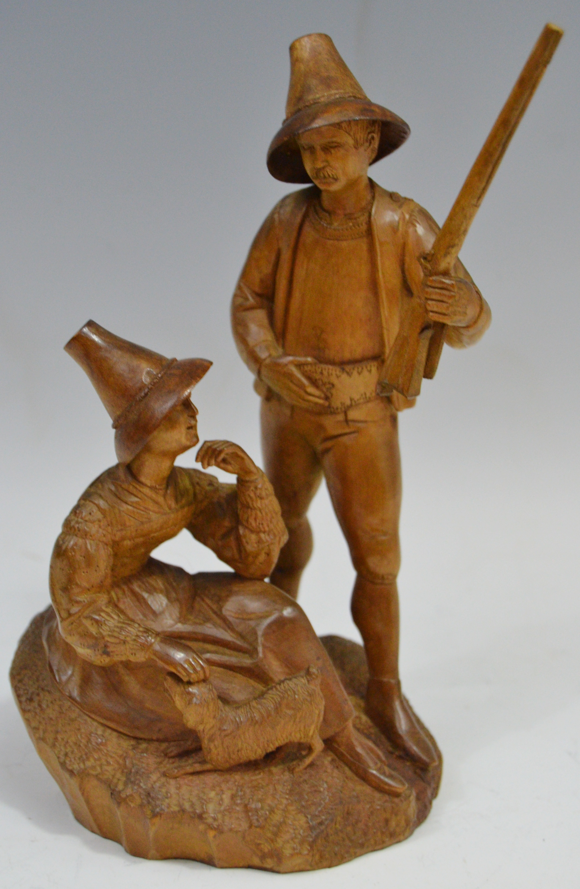 A 19th century Black Forest figural group, of a Forester standing with his gun,