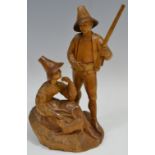A 19th century Black Forest figural group, of a Forester standing with his gun,