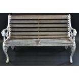 A Victorian style garden bench, the shaped ends cast with masks and scrolls,