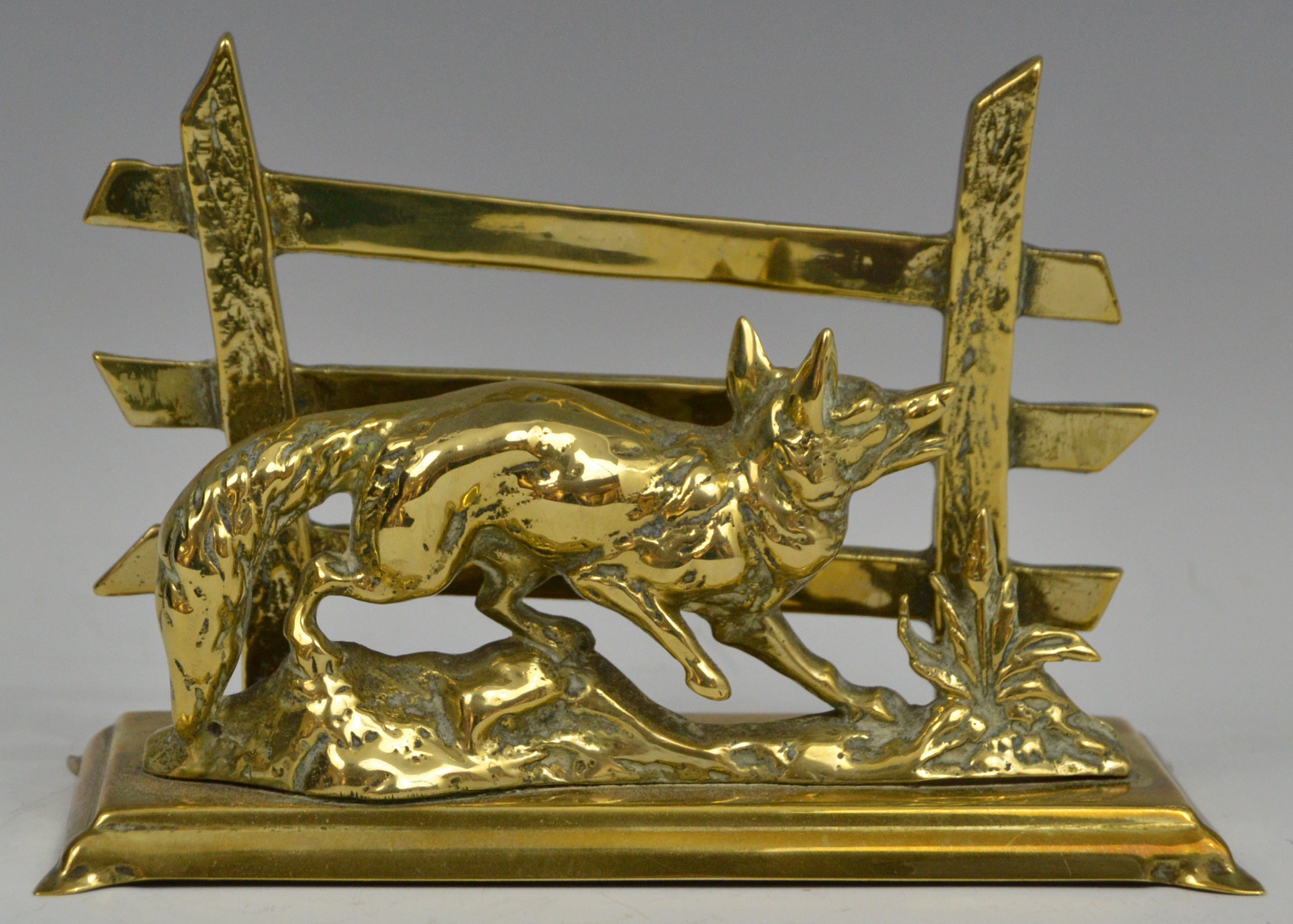 An early 20th century brass letter rack, cast with a fox before a three bar fence,. 17.
