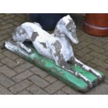 A composite garden model of an elegantly poised recumbent greyhound, plinth base,