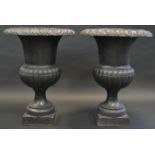 A pair of late Victorian/early 20th century cast iron campana shaped garden urns, stepped base ,