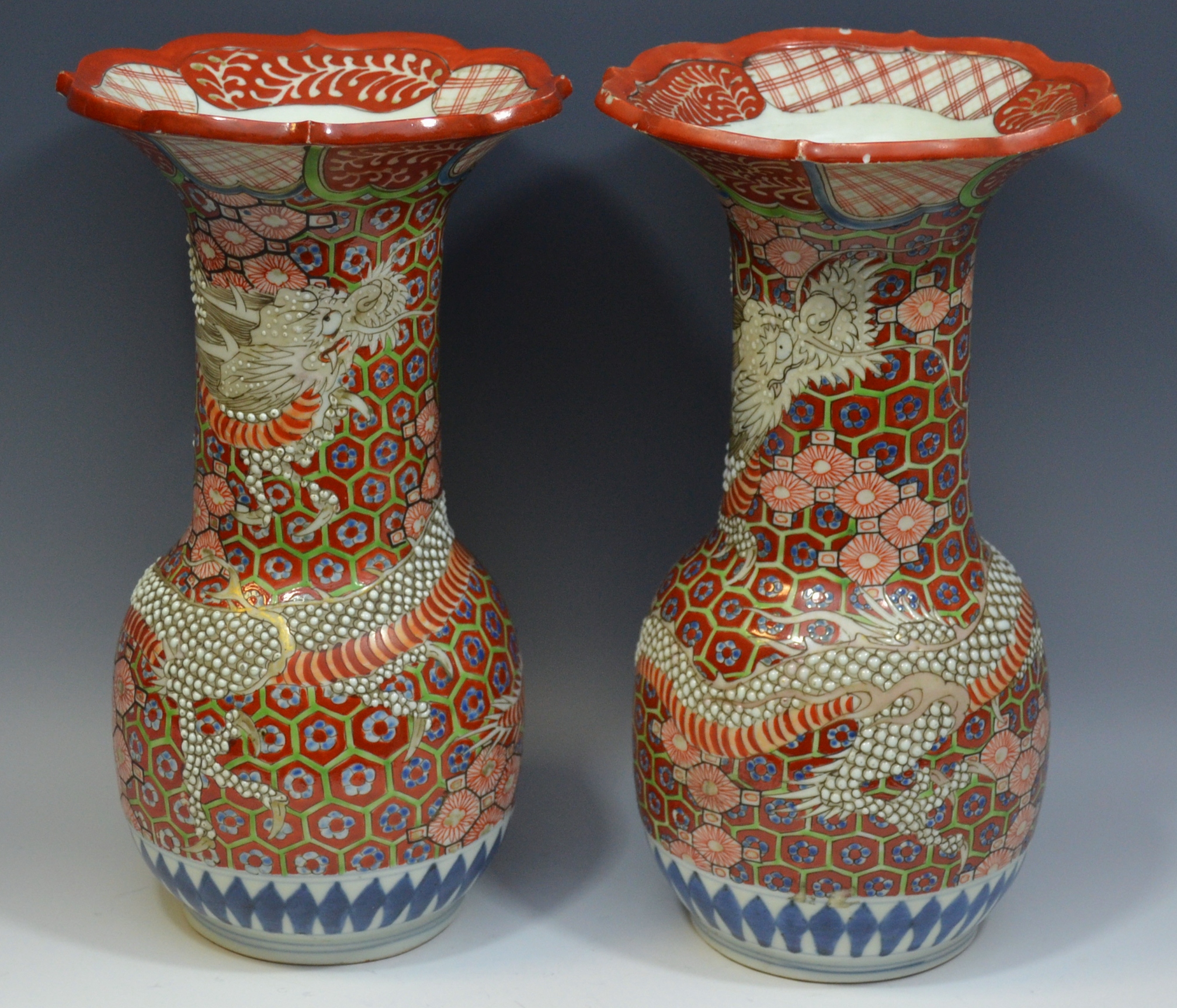 A pair of Japanese vases, decorated in relief with scaled dragon,