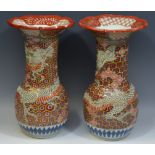 A pair of Japanese vases, decorated in relief with scaled dragon,