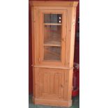 A modern pine floor standing corner cabinet, stepped cornice, canted angles, glazed door to top,