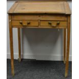 A Victorian pine lectern desk, having a sloping lift-up top above a pair of small drawers,