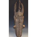 Tribal Art - an African mask, horned cresting, stylised geometric features,