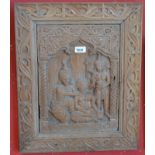 An Indian hardwood architectural fragment, the central panel carved with a deity and attendants,