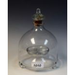 A clear glass bell shaped fly catcher, the knopped cover moulded with three flies,